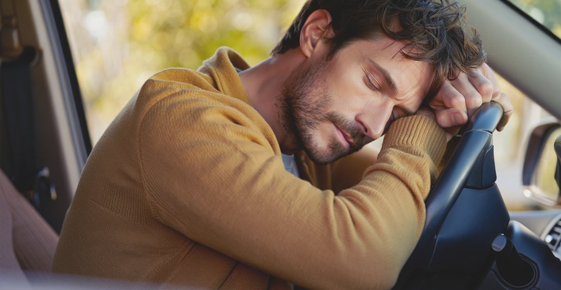 МУжчина спит, положив голову на руль машины