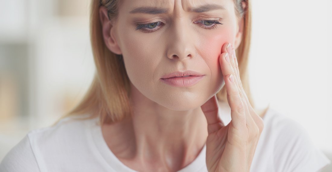 Женщина держится за лицо